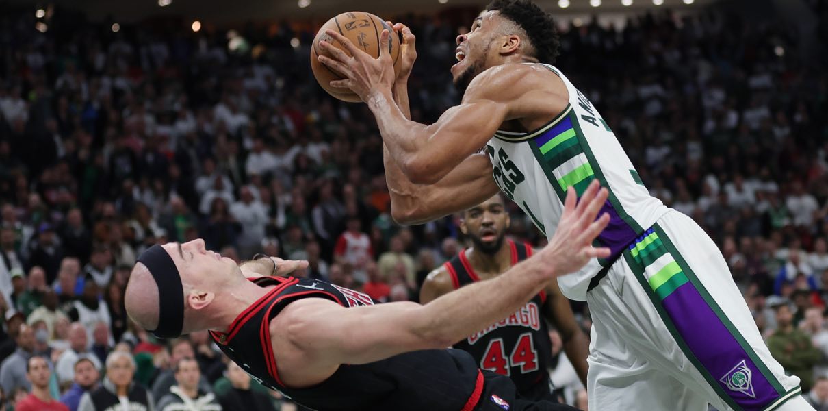 Alex Caruso of the Chicago Bulls attempts to draw an offensive foul on Giannis Antetokounmpo.